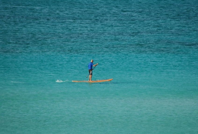 hombre navegando mientras practica paddle surf.jpg